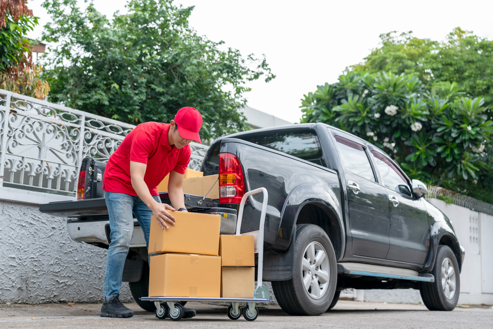 Man loading cartons on pickup truck