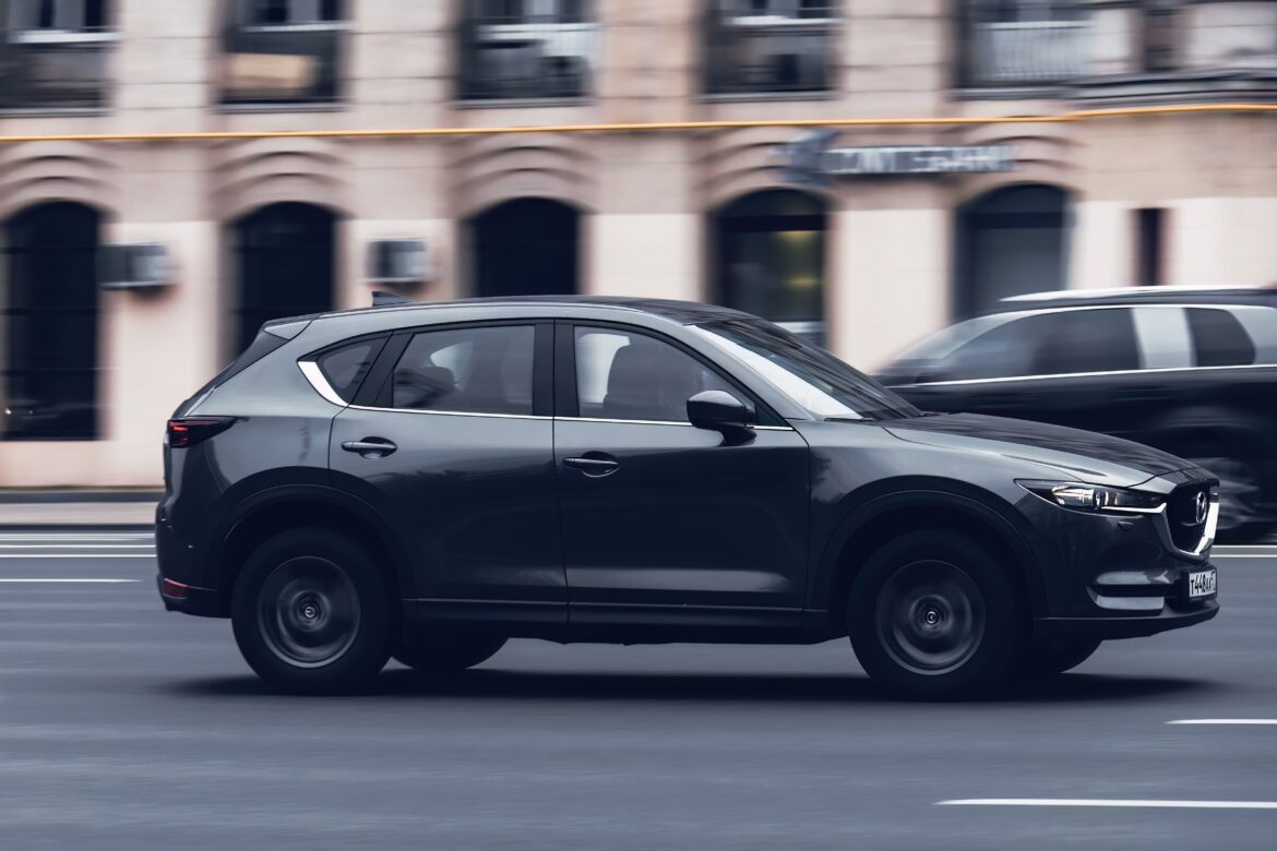 Mazda CX-5 2.5 L Skyactiv-G car with old man driver on the city road in motion