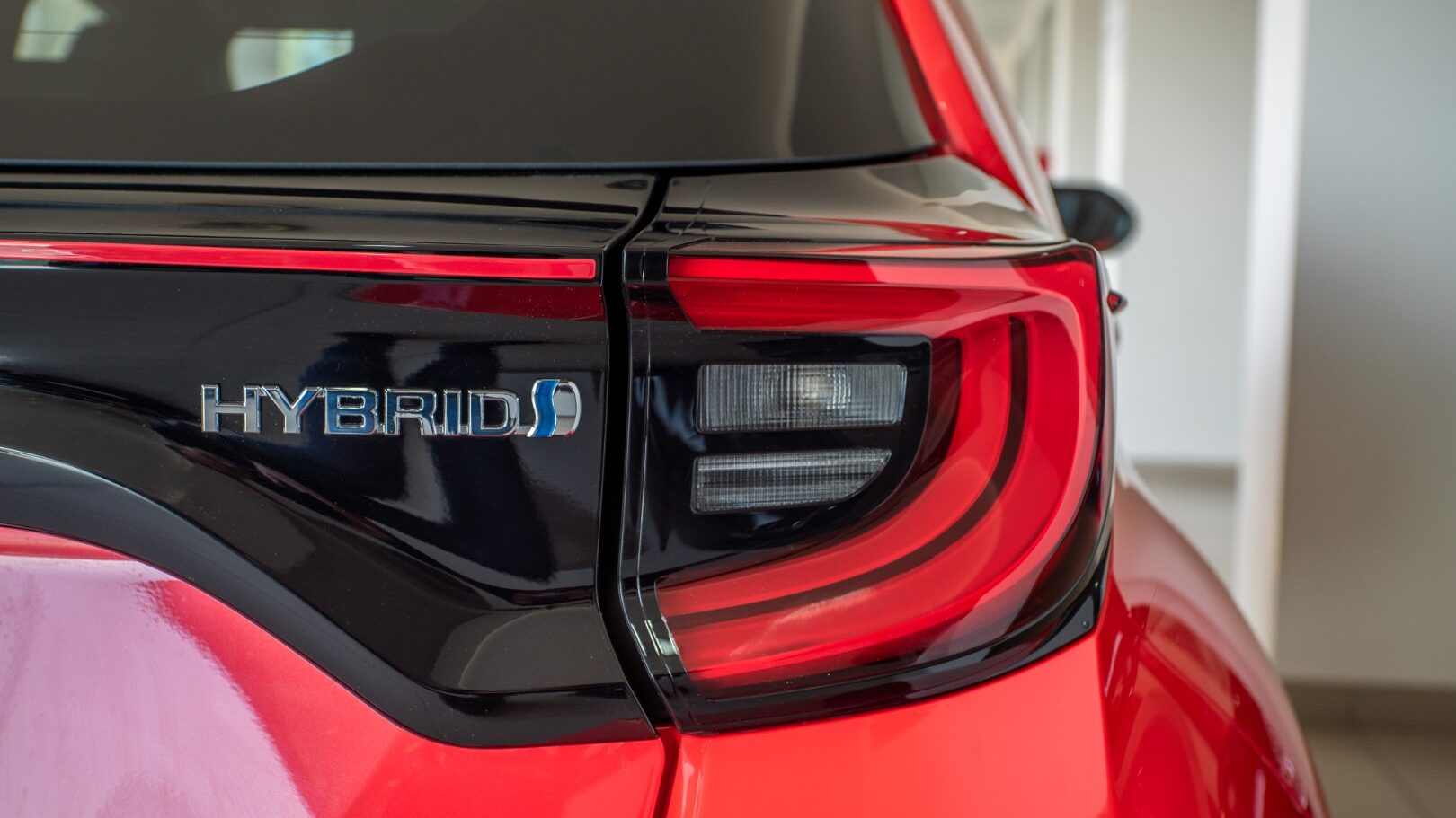 Close up of a logo of Hybrid technology in the car on the back of the car near the tailight