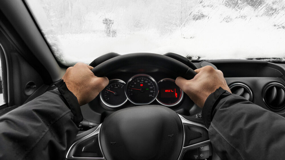 close up of a person's hands holding tight the steering wheel trying to minimize the steering wheel vibration problem