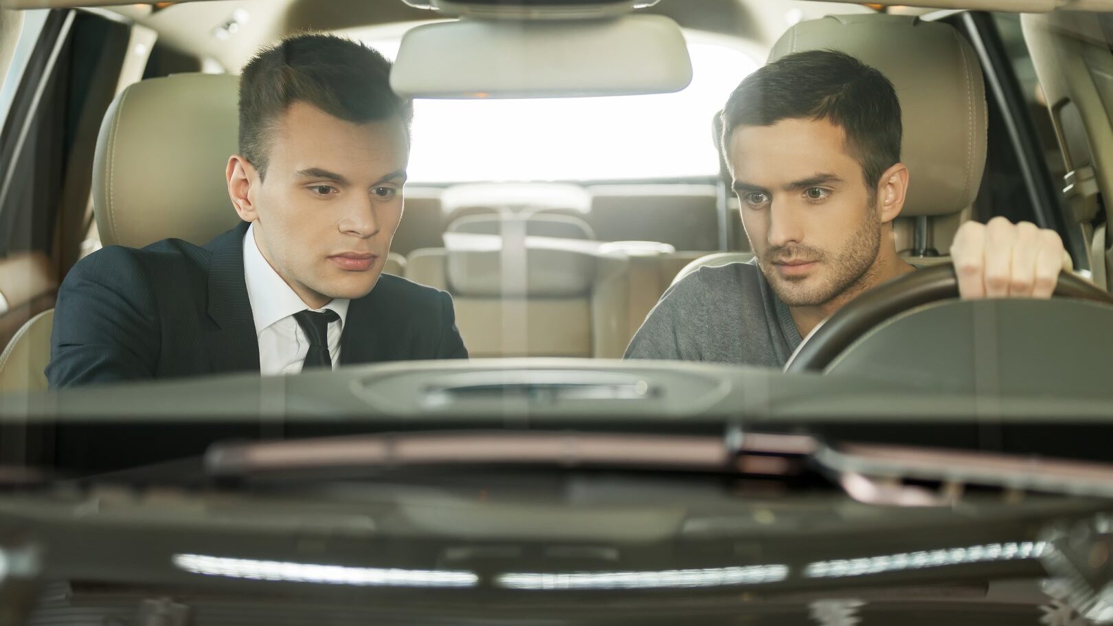 A buyer and a seller sitting in the car and checking the car condition